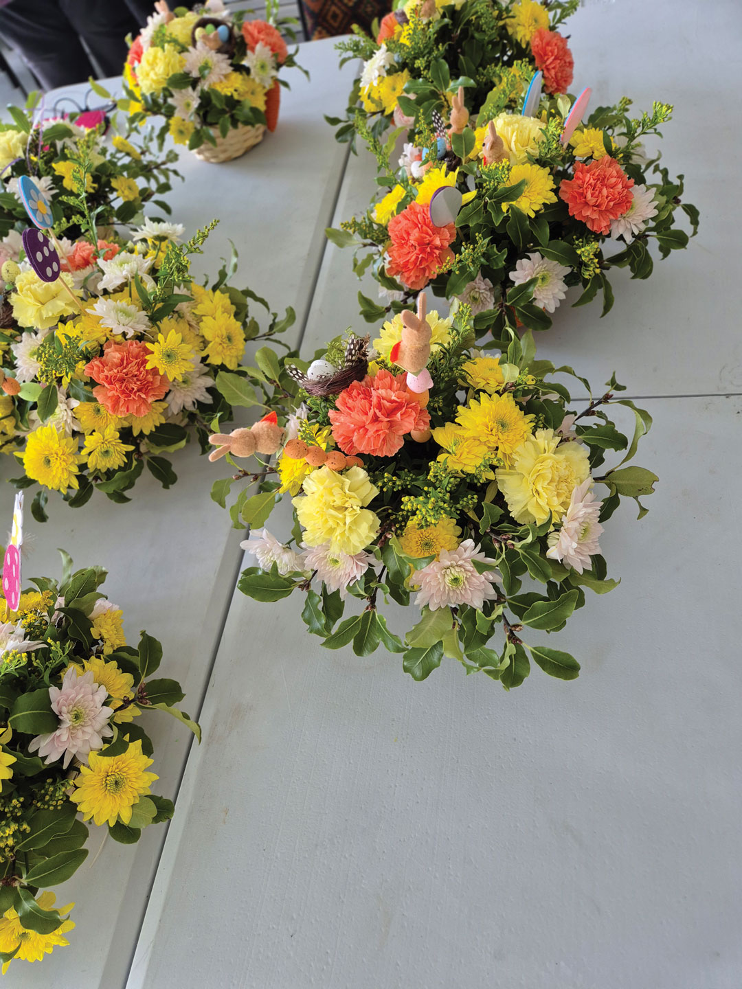 Olivias Flowers arrangements on tables with yellow flowers
